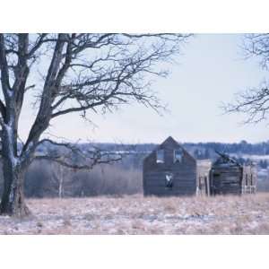 Old Wooden Derelict and Ramshackled Farm Buildings in a Snow Covered 